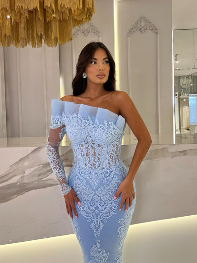 baby blue dress featuring an asymmetrical neckline and a ruffle detail