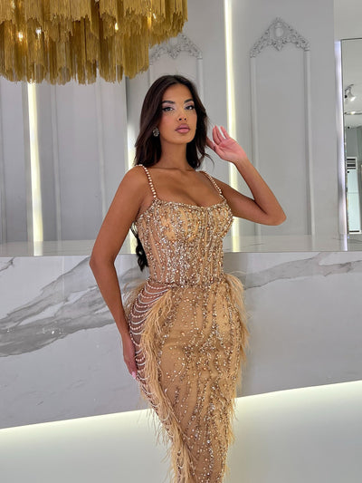 golden evening gown featuring rows of pearls on the sides
