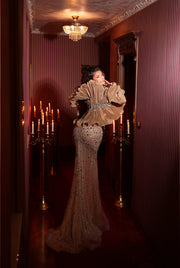 a nude evening gown featuring a bolero design