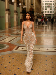 a nude evening gown with silver details and feathers